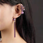 Charming Perfections Trendy One Ear Purple Amethyst Flower Earring Jewelry on ear with grey background Pure Natural Stone Crystal Beauty Jewelry. Perfect for Birthday Gifts, Anniversary, Black Friday, Christmas, or any Occasion. Perfect Present for a Loved one. Fashion and Style. Very Fashionable for that special someone.